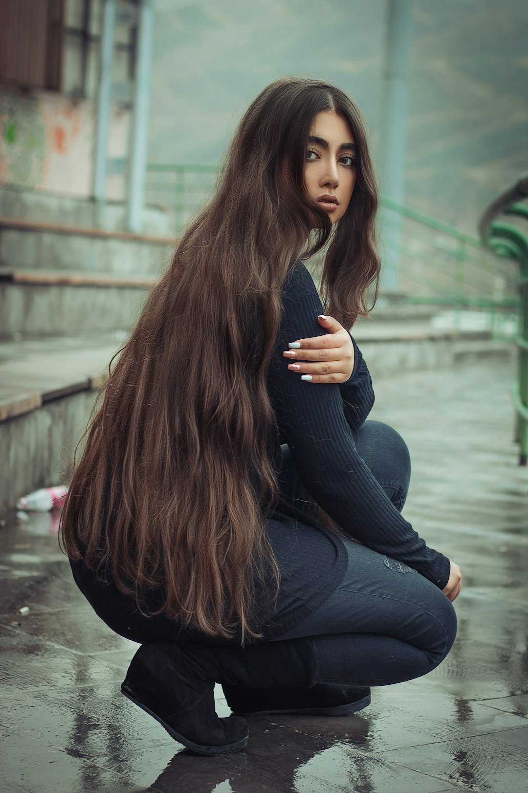 a-woman-with-long-hair-kneeling-down-on-the-ground-v0qmimenykk